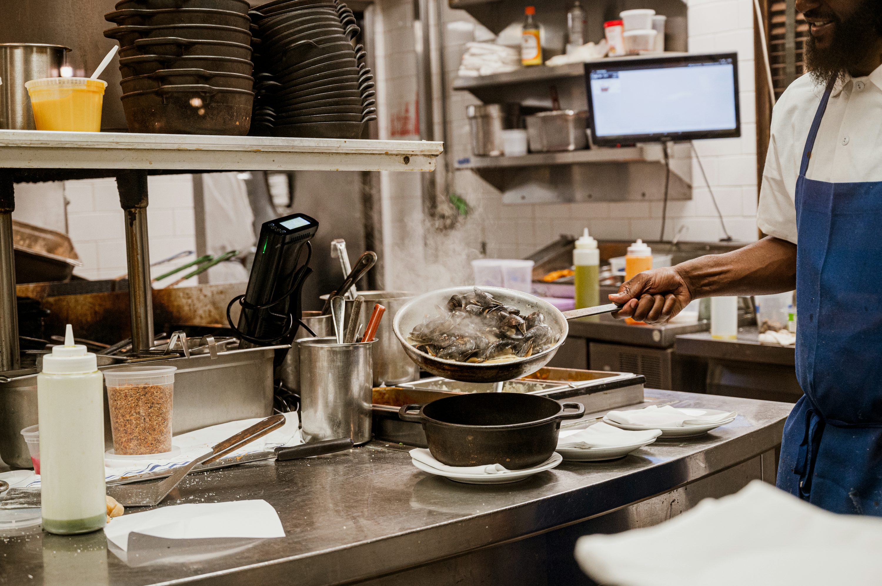 Køkkenhold arbejder ved en professionel køkkenlinje under service